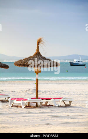 Leere Liegestühle und Sonnenschirme am Strand von Port de Alcudia Stockfoto