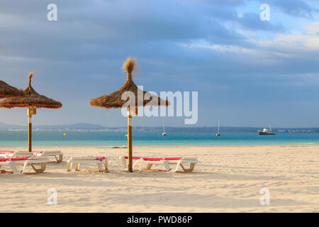 Leere Liegestühle und Sonnenschirme am Strand von Port de Alcudia Stockfoto