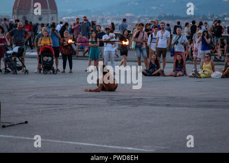 Feuer Tänzer bei Sonnenuntergang, während Massen in die Piazzale Michelangelo, Florenz, Italien. Stockfoto