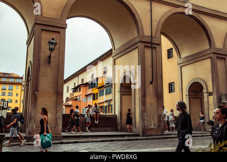 Touristen genießen Sie einen lauen Sommerabend auf dem Arno durch einen Bogen unter dem Vasari Korridor in Florenz, Italien. Stockfoto