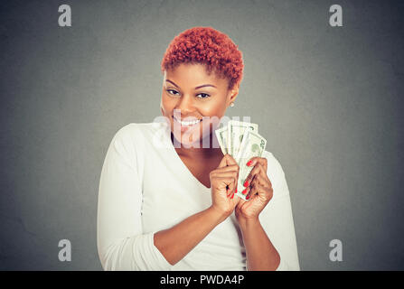 Portrait von super Glücklich, aufgeregt, erfolgreiche junge Frau mit Geld-Scheine in der Hand, auf grauem Hintergrund. Konzept der finanzielle Belohnung Stockfoto