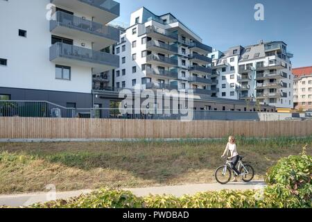 Wien, Eine Radfahrerin der modernen Wohnhausanlage Schiffmühlenstraße 120 - Wien, moderne Apartment House Stockfoto