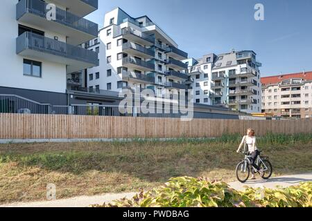 Wien, Eine Radfahrerin der modernen Wohnhausanlage Schiffmühlenstraße 120 - Wien, moderne Apartment House Stockfoto