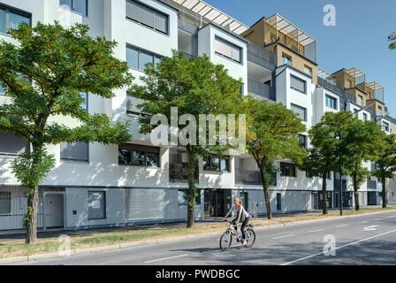 Wien, Eine Radfahrerin der modernen Wohnhausanlage Schiffmühlenstraße 120 - Wien, moderne Apartment House Stockfoto