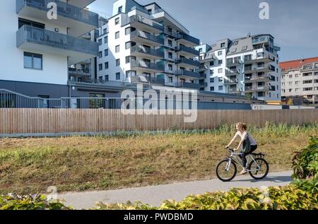 Wien, Eine Radfahrerin der modernen Wohnhausanlage Schiffmühlenstraße 120 - Wien, moderne Apartment House Stockfoto