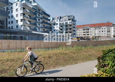 Wien, Eine Radfahrerin der modernen Wohnhausanlage Schiffmühlenstraße 120 - Wien, moderne Apartment House Stockfoto