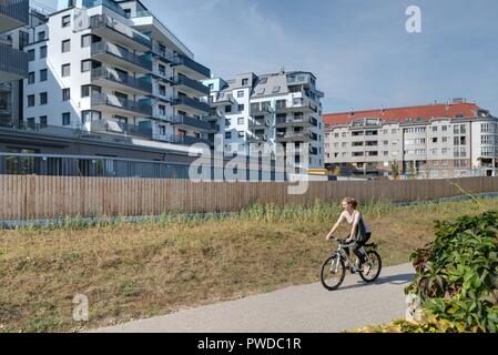 Wien, Eine Radfahrerin der modernen Wohnhausanlage Schiffmühlenstraße 120 - Wien, moderne Apartment House Stockfoto