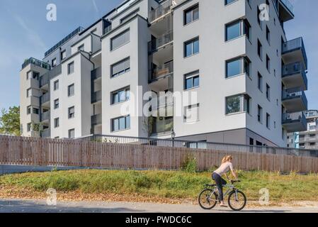 Wien, Eine Radfahrerin der modernen Wohnhausanlage Schiffmühlenstraße 120 - Wien, moderne Apartment House Stockfoto