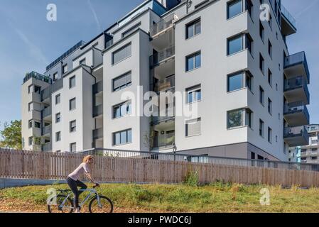 Wien, Eine Radfahrerin der modernen Wohnhausanlage Schiffmühlenstraße 120 - Wien, moderne Apartment House Stockfoto