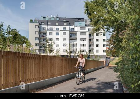 Wien, Eine Radfahrerin der modernen Wohnhausanlage Schiffmühlenstraße 120 - Wien, moderne Apartment House Stockfoto