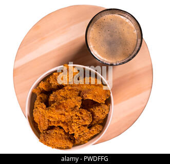 Panierte frittierte Chicken Nuggets serviert in einem Takeaway Whirlpool mit einem Pint schaumiges Bier von oben gesehen Stockfoto