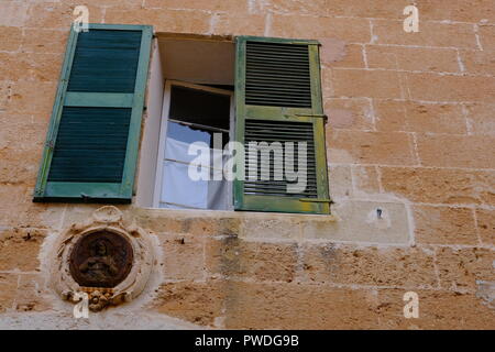 Plakette Darstellung Christus unter der Hälfte öffnen grünen Fensterläden, Ciutadella Menorca Spanien Stockfoto