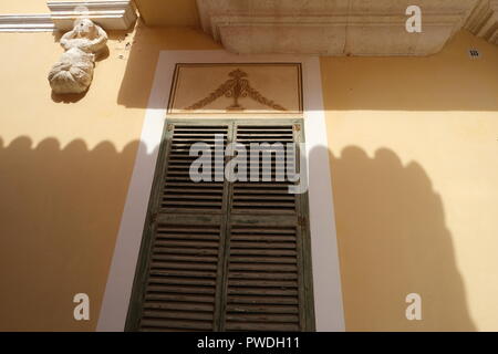 Verwitterte grün Shutter mit Schatten von Balkon über Ciutadella Menorca Spanien cast Stockfoto