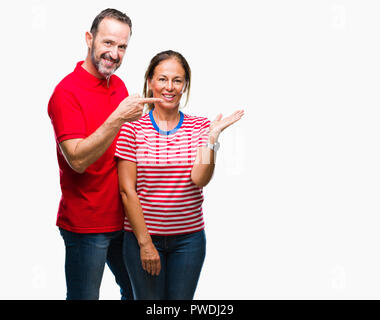 Mittleres Alter spanischer Paar in Liebe über isolierte Hintergrund erstaunt und lächelt in die Kamera während der Präsentation mit Hand und zeigte mit dem Finger. Stockfoto