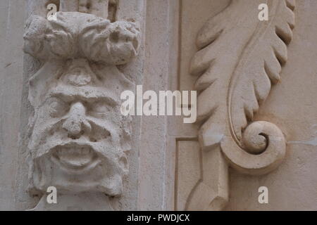 Dekorative Gesicht und Emblem Schnitzereien an der Kirchenmauer in Ciutadella Menorca Spanien Stockfoto