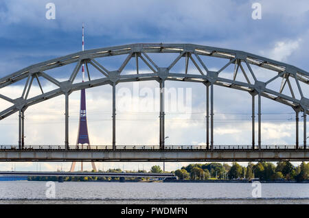 Eisenbahnbrücke, Riga, Lettland, über den Fluss Daugava, mit der Radio- und TV-Turm im Hintergrund Stockfoto