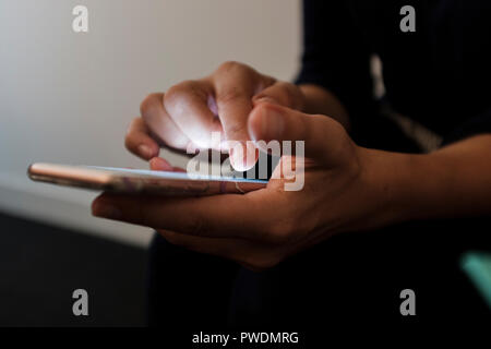 Selektiver Fokus, Nahaufnahme von einer Frau mit einem Touchscreen smartphone Stockfoto