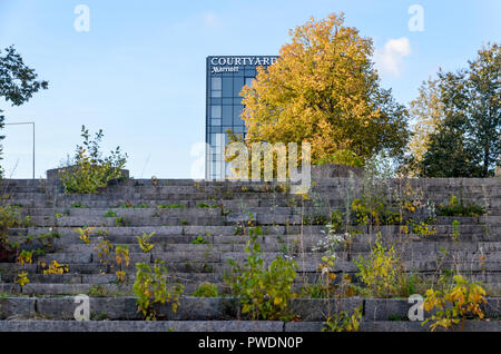 Wachsendes Gras auf der Treppe des stillgelegten Vilnius Palast der Konzerte und Sport, mit phantastischen Hotel im Hintergrund Stockfoto