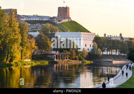 Gediminas Hill und Turm Schloss, in Vilnius, Litauen, durch die Neris, mit Menschen zu Fuß auf der Promenade Stockfoto