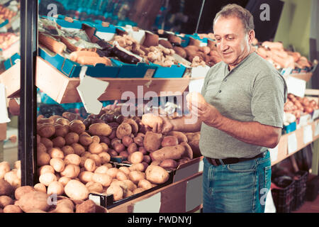 Netter Mann ist die Wahl Kartoffel in der Gemüse speichern Stockfoto