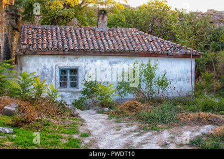 Altes Haus mit einem Ziegeldach im Innenhof mit einem Stone Fence Stockfoto