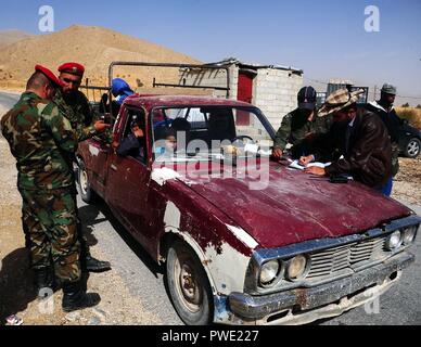 (181015) - DAMASKUS, Oktober 15, 2018 (Xinhua) - syrische Soldaten inspizieren Papiere der syrischen Flüchtlinge aus dem Libanon am Zamrani Kreuzung, in der Gegend von Damaskus, Syrien, am Okt. 15, 2018. Rund 835 syrische Flüchtlinge kehrten in ihre Heimat Montag aus verschiedenen Bereichen im Libanon einschließlich Tripolis und Nabatieh. (Xinhua / Ammar Safarjalani) (Hy) Stockfoto