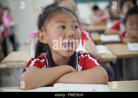 (181016) - FENGYANG, Oktober 16, 2018 (Xinhua) - Kinder haben eine englische Klasse Xiaogang Schule an Xiaogang Dorf in Fengyang County, der ostchinesischen Provinz Anhui, on Sept. 27, 2018. Xiaogang ist in Fengyang (Phoenix) Grafschaft. Die Grafschaft, wie seine mythologischen Namensvetter, hat durch Hunderte von reinkarnationen im Laufe der Jahrhunderte gegangen, wie Gemeinschaften wie Xiaogang Schlacht eine unbeständige Umgebung, um genügend Nahrung zu überleben Eke. 1978, 18 Bauern kamen zusammen, um für eine verdeckte Treffen in einer der das Dorf Lehmhütte zu Hause, und stimmte schließlich der geheime Vereinbarung zur Aufteilung gemeinschaftlich besessen Farm zu unterzeichnen Stockfoto