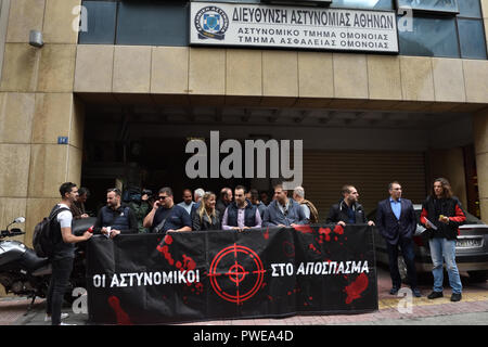 Athen, Griechenland. 16. Okt 2018. Polizeibeamte stehen vor der Polizei Station Omonia halten ein Banner mit der Aufschrift "Polizisten mit Waffengewalt" einer früheren Angriff an dieser Station in Athen, Griechenland, zu verurteilen. Credit: Nicolas Koutsokostas/Alamy Leben Nachrichten. Stockfoto