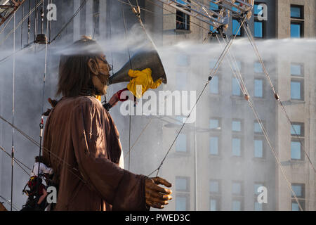 Liverpool, Großbritannien. 6. Oktober 2018. Tag 2 des Royal De Luxe riesigen spektakulären, Feuerwehrleute stellen der Riese mit einem Drink vor der Leber Gebäude. Stockfoto