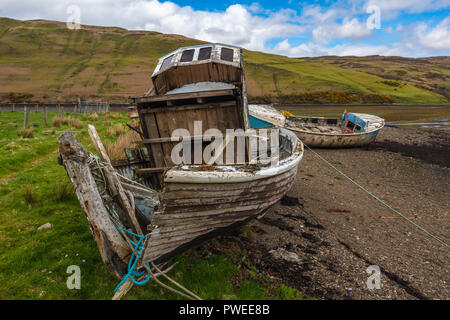 Alte und verlassene Fischerboote bei Ebbe am Loch Harport, Isle of Skye, Schottland, Großbritannien Stockfoto