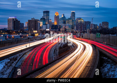 Leichte Wanderwege und die Skyline von Minneapolis, Minnesota in der Dämmerung als von der 24. Straße zu Fuß Brücke über die Interstate 35 W. gesehen Stockfoto