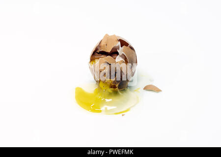 Gebrochene gebrochene Brown Organic Chicken Egg, auf weißem Hintergrund. Eigelb und weißen Verschütten auf die Oberfläche. Stockfoto