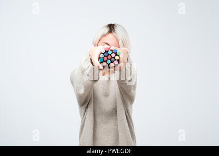 Kaukasische Frau mit Magic Farbstifte auf weißem Hintergrund. Künstler, die versuchen, eine Farbe zu wählen Stockfoto