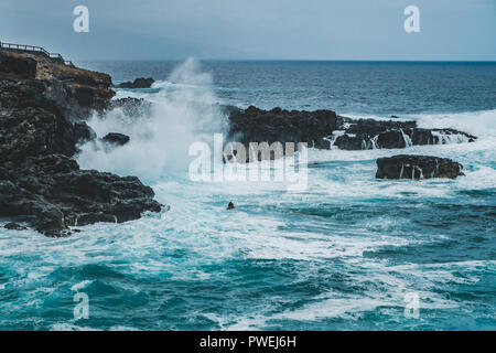 Ozean Wellen gegen schwarzen Felsen an der Küste - Stockfoto