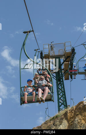 Sessellift. Menschen mit spektakulärem Blick über Alum Bay und den Strand. Isle of Wight. Atemberaubende Fahrten zum Strand hinunter und dann wieder ein. Stockfoto