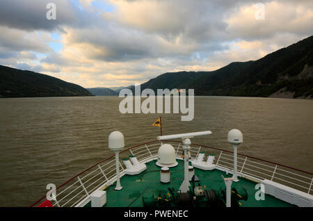 Serbien, Rumänien Südkarpaten, Serbische Karpaten, Banat Berge, Djerdap Nationalpark, Katarakte, Eisen Tore, Donau Water Gap, Flusskreuzfahrt auf der Donau, Donau Navigation, aROSA 393 Mia, Flusslandschaft, Donau Landschaft, Berge, bergige Landschaften, steilen Felsen, Abend, Sonnenuntergang, dunkle Wolken Stockfoto
