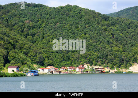 Serbien, Rumänien Südkarpaten, Serbische Karpaten, Banat Berge, Djerdap Nationalpark, Katarakte, Wohnhäuser in der Nähe von orsova an der Rumänischen River Bank, Eisen Tore, Donau Water Gap, Flusskreuzfahrt auf der Donau, Donau Navigation, Flusslandschaft, Donau Landschaft, Berge, Berglandschaft, steil Felsen Stockfoto