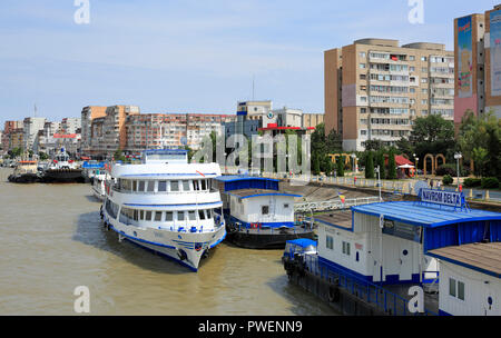 Rumänien, Tulcea an der Donau, Saint George Zweig, Tulcea County, Dobrudscha, Tor zum Donaudelta, Blick auf die Stadt, Hafen, business Häuser und Wohnanlagen, Mehrfamilienhäuser, Wohnblocks, Donauufer, Riverwalk, Uferpromenade, Schiffsanlegestelle, Schiffe, Boote, Ausflug Schiff, Donau Navigation Stockfoto