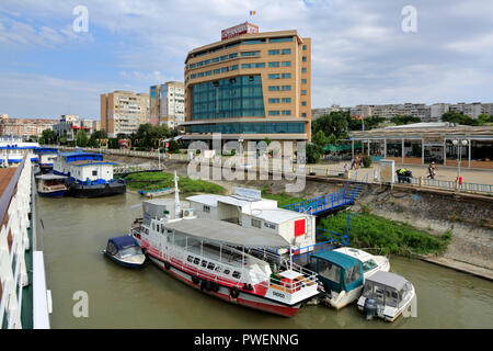 Rumänien, Tulcea an der Donau, Saint George Zweig, Tulcea County, Dobrudscha, Tor zum Donaudelta, Blick auf die Stadt, Hafen, business Häuser und Wohnanlagen, Mehrfamilienhäuser, Wohnblocks, Esplanada Hotel, Donauufer, Riverwalk, Uferpromenade, Schiffsanlegestelle, Schiffe, Boote, Ausflug Schiff, Donau Navigation Stockfoto