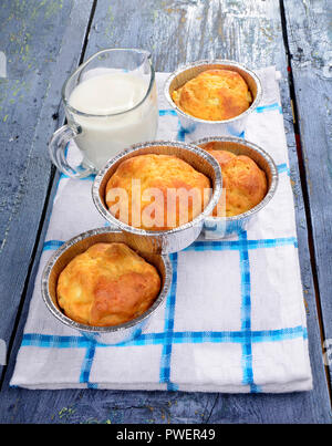 Snack Muffins, salzigen Kuchen Muffins mit Käse auf einer Holzplatte, ein Glas frische Milch - selektive Fokus Stockfoto