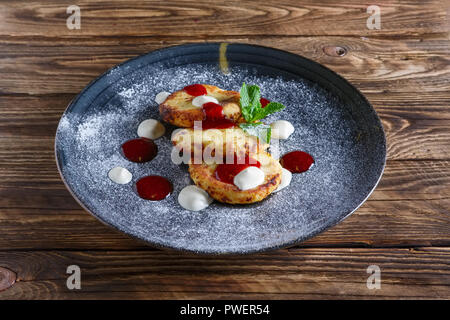 Käse Pfannkuchen serviert mit saurer Sahne und Erdbeermarmelade Stockfoto