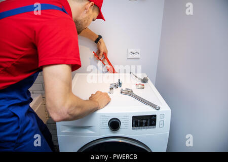 Klempner installation Waschmaschine im heimischen Badezimmer Stockfoto