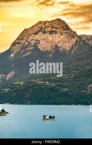 Hautes-Alpes (05). See Serre-Ponçon. Die Bucht von Saint-Michel und die Kapelle Saint-Michel mit Blick auf die Gipfel des Grand Morgon Stockfoto