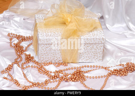 Weißes Kästchen mit goldenen Bogen auf weißem Hintergrund. Luxus Paket. Stockfoto