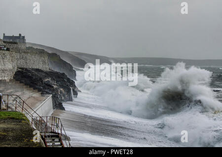 Porthleven Hafen, Porthleven Clock Tower Cornwall und Klippen mit großen Absturz Wellen während Winterstürmen Stockfoto