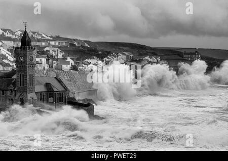 Porthleven Clock Tower Cornwall und Klippen mit großen Sturzwellen bei Winterstürmen, stürmischem Wetter, Stockfoto