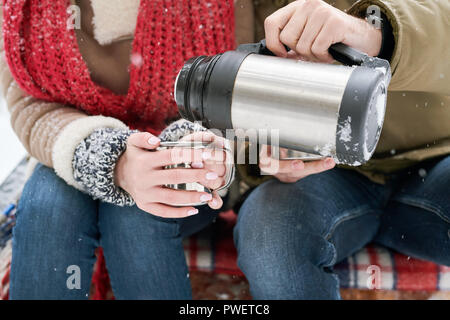 Nahaufnahme des unkenntlich junge Paar beim heißen Kakao während Datum im Winter im Freien Stockfoto