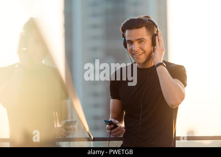 Happy Sportler Hören von Musik Stockfoto
