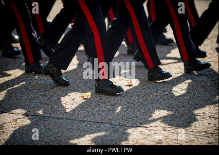 Soldaten marschieren in hellen Herbstsonne mit Schatten auf strukturierte Kies Stockfoto