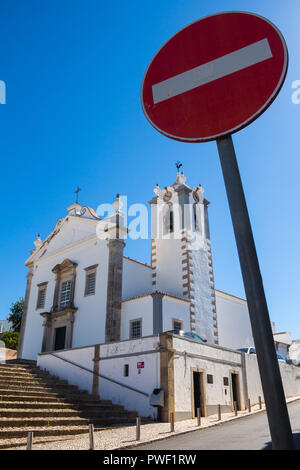 Saint Martinho Kirche mit ihrer typisch portugiesische Architektur. Keinen Eintrag Verkehrsschild im Vordergrund. Strahlend blauer Himmel. Estoi, Portugal. Stockfoto